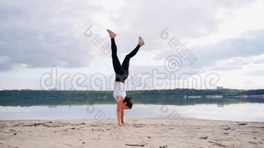 河沙滩<strong>上</strong>的一个年轻女孩练习瑜伽。 <strong>海滩上</strong>的女孩<strong>站在</strong>桥<strong>上</strong>的姿势。
